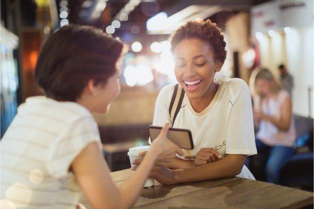 One woman showing a friend the Rosetta Stone app on her phone.
