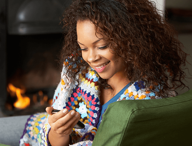 A woman taking a lesson on her phone, smiling.